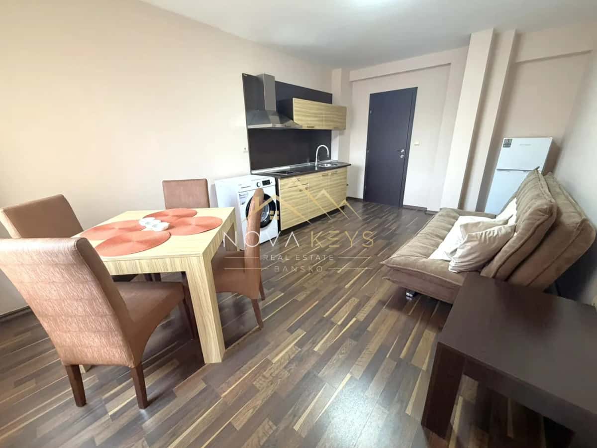 Open-plan living room with kitchenette and dining table, three-bedroom apartment for rent in the Bansko ski area.