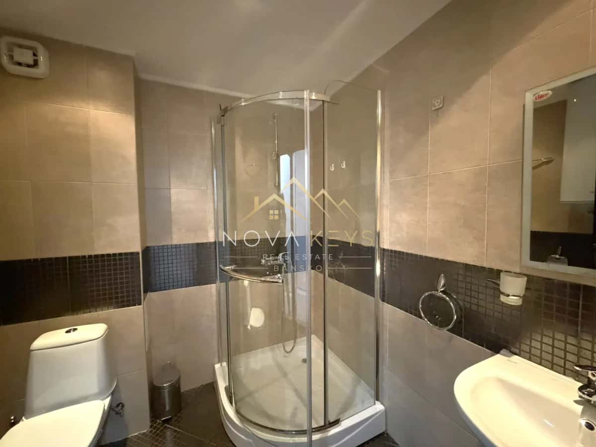 Bathroom with curved glass shower and toilet, three-bedroom apartment for rent in the Bansko ski area.