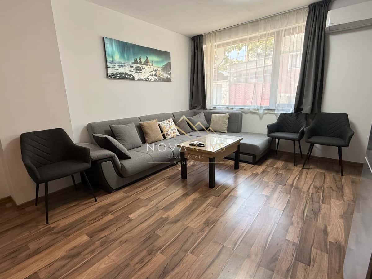 Living room with sectional sofa and coffee table, three-bedroom apartment for rent in Bansko centre.
