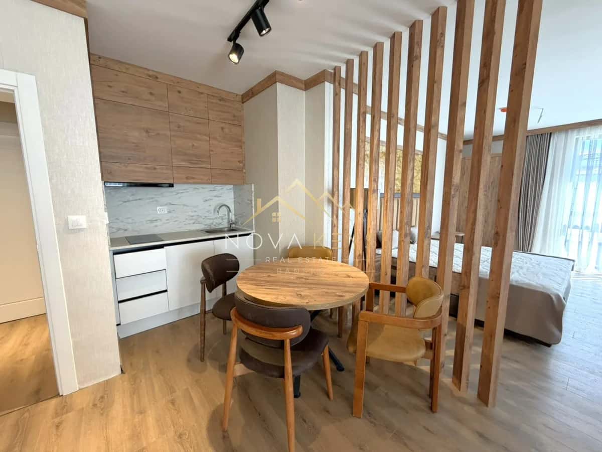 Studio interior with kitchenette and round dining table, studio for sale in the Bansko ski area.