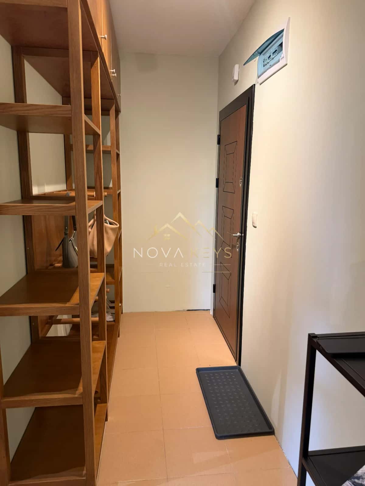 Narrow hallway with wooden shelving and a brown door, two-bedroom apartment for sale in Pirin Golf.