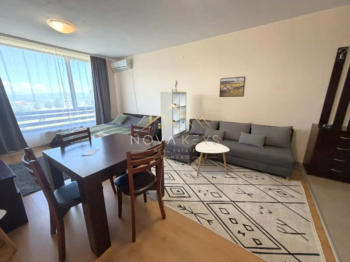 living and dining room with gray sofa and large window, studio for rent in Razlog.