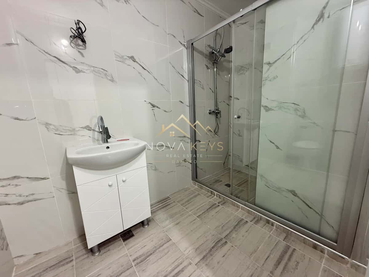 Bathroom with vanity and glass shower, two-bedroom apartment for sale in Bansko centre.