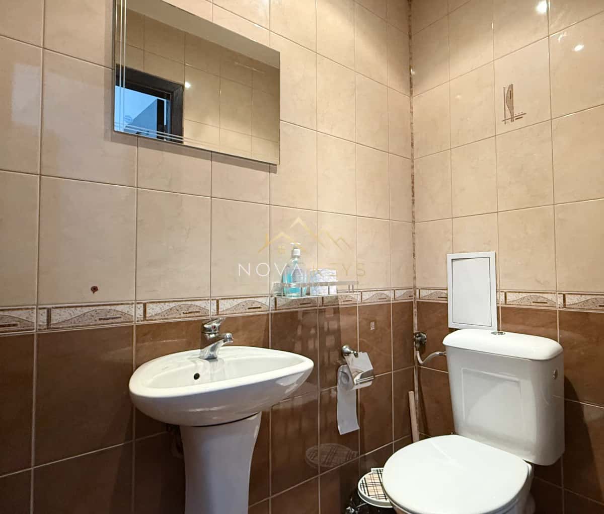 small tiled bathroom with sink and toilet, three-bedroom apartment for rent in Bansko centre.