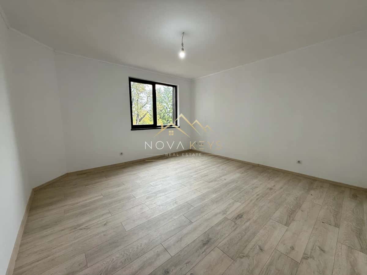 empty room with wood-look flooring and window, two-bedroom apartment for sale in Bansko centre.