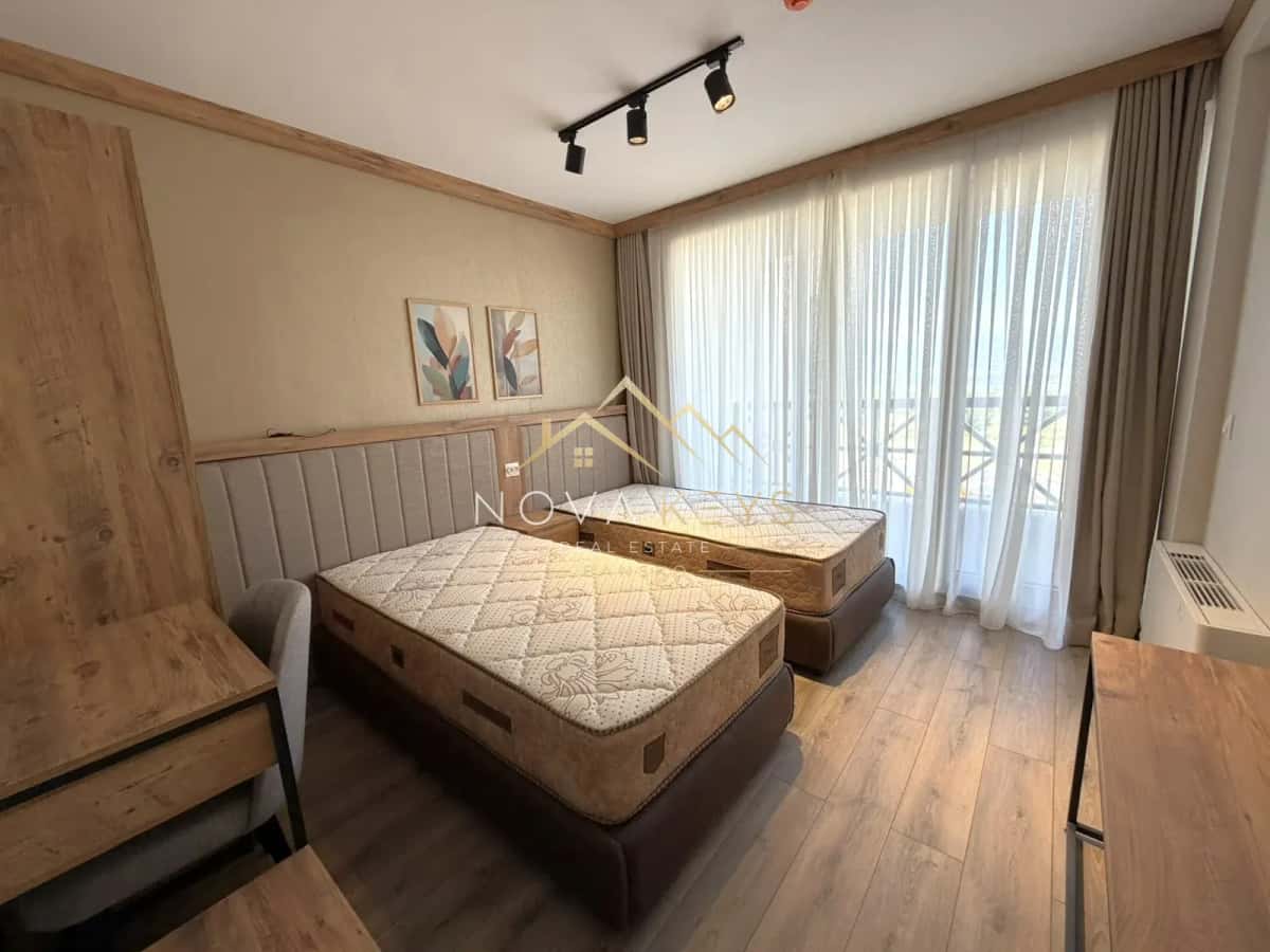 bedroom with two single beds and large windows, three-bedroom apartment for sale in the Bansko ski area.