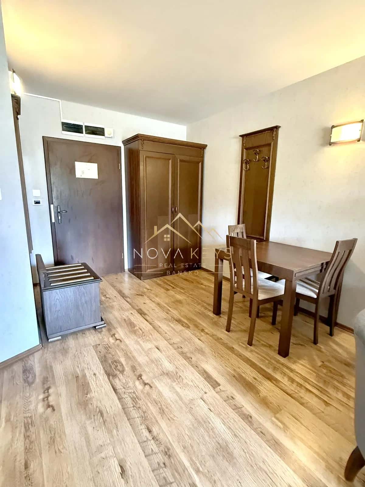 furnished room with dining table and wardrobe, two-bedroom apartment for sale in the Bansko ski area.