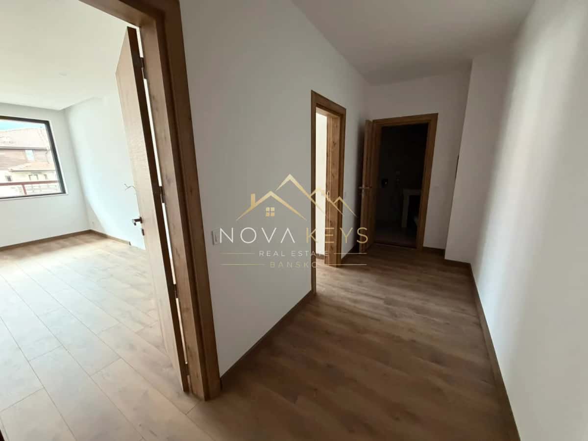Empty hallway with wood flooring and open doorways, two-bedroom apartment for sale in the Bansko ski area.