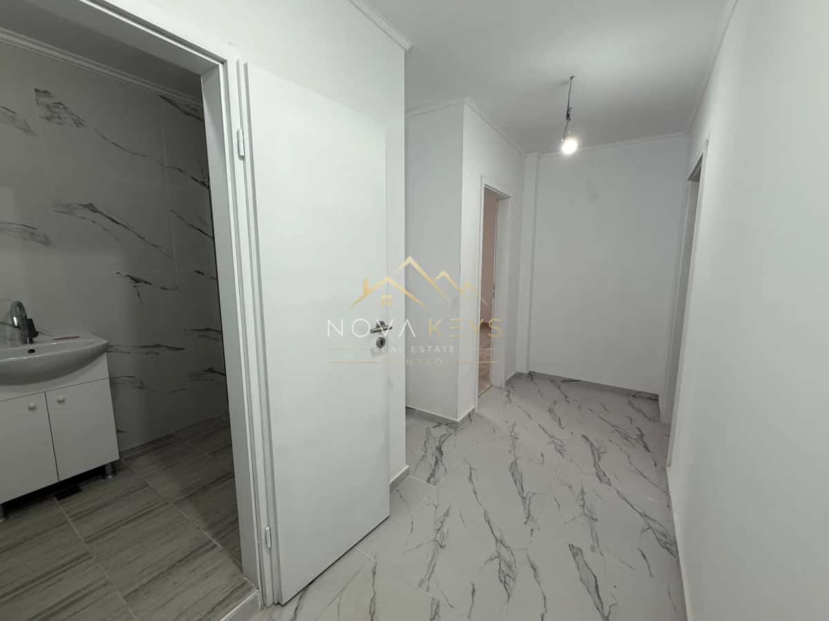 empty hallway with marble-pattern floor and open bathroom doorway, two-bedroom apartment for sale in Bansko centre.