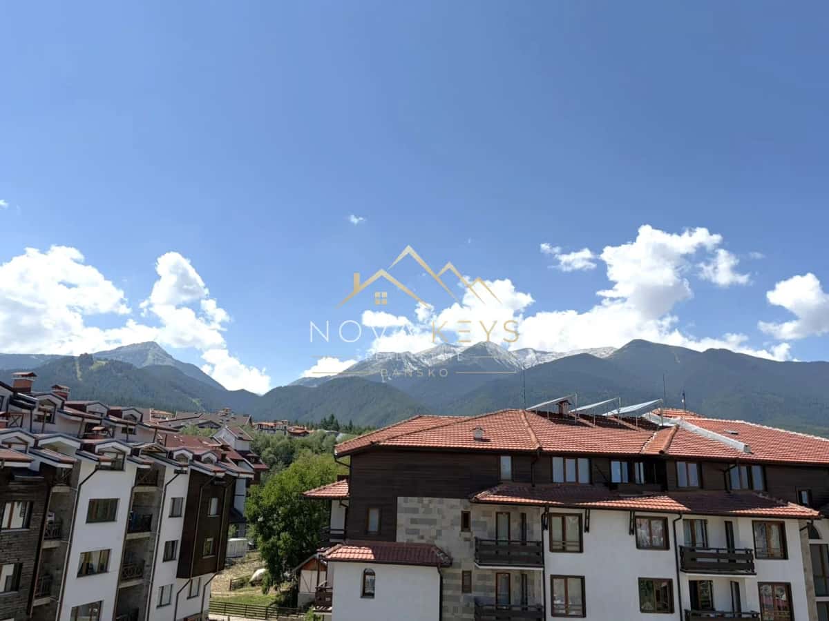 Mountain view over red-roofed buildings, two-bedroom apartment for sale in the Bansko ski area.
