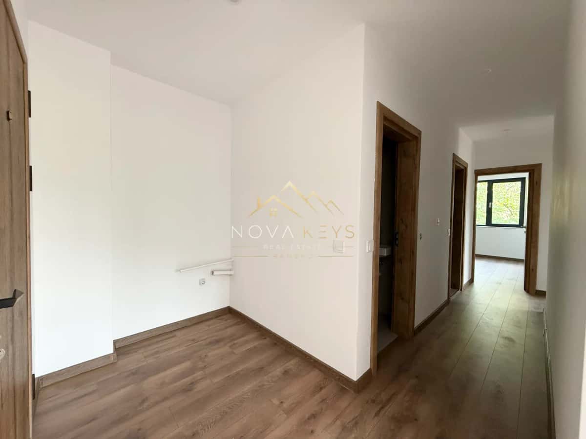 Empty hallway with wood flooring and doorways, three-bedroom apartment for sale in the Bansko ski area.