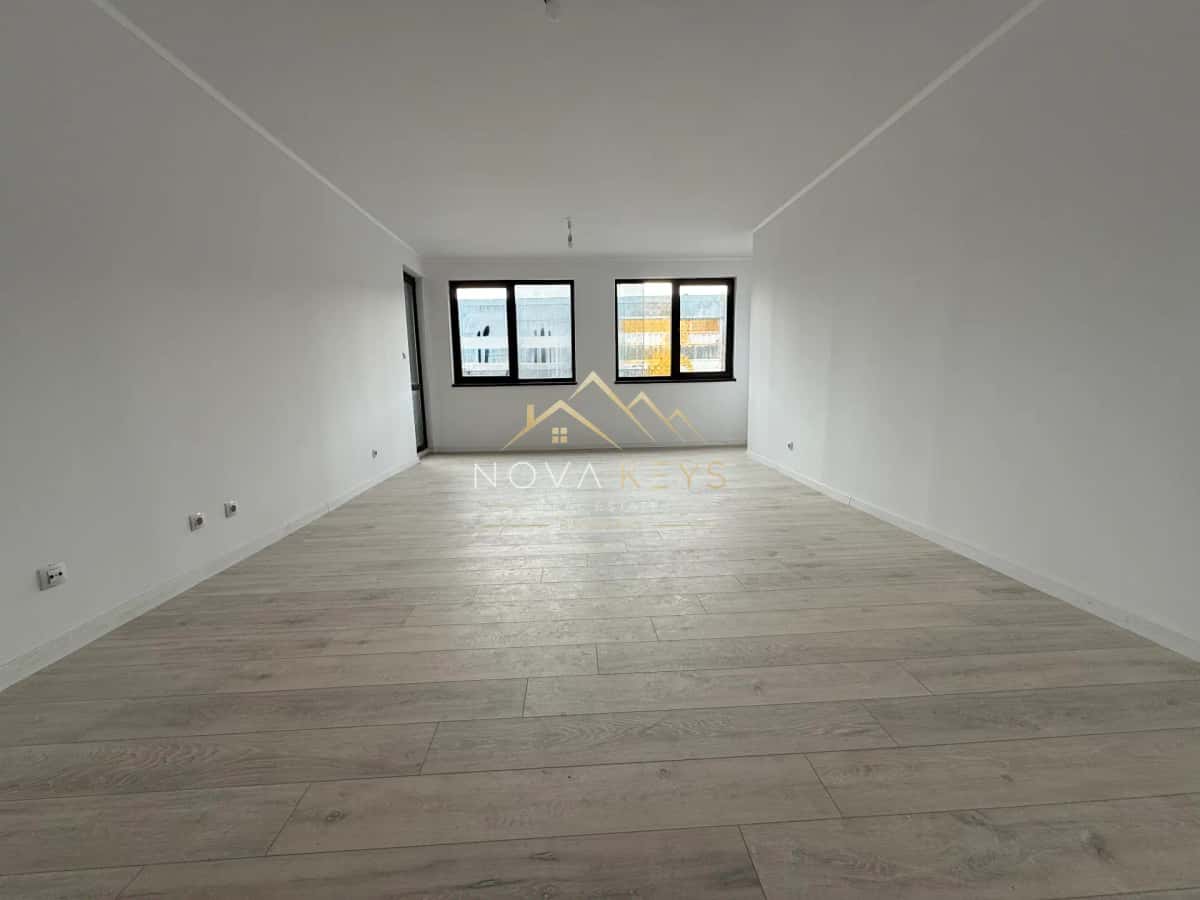 unfurnished room with wood-look flooring and two windows, two-bedroom apartment for sale in Bansko.