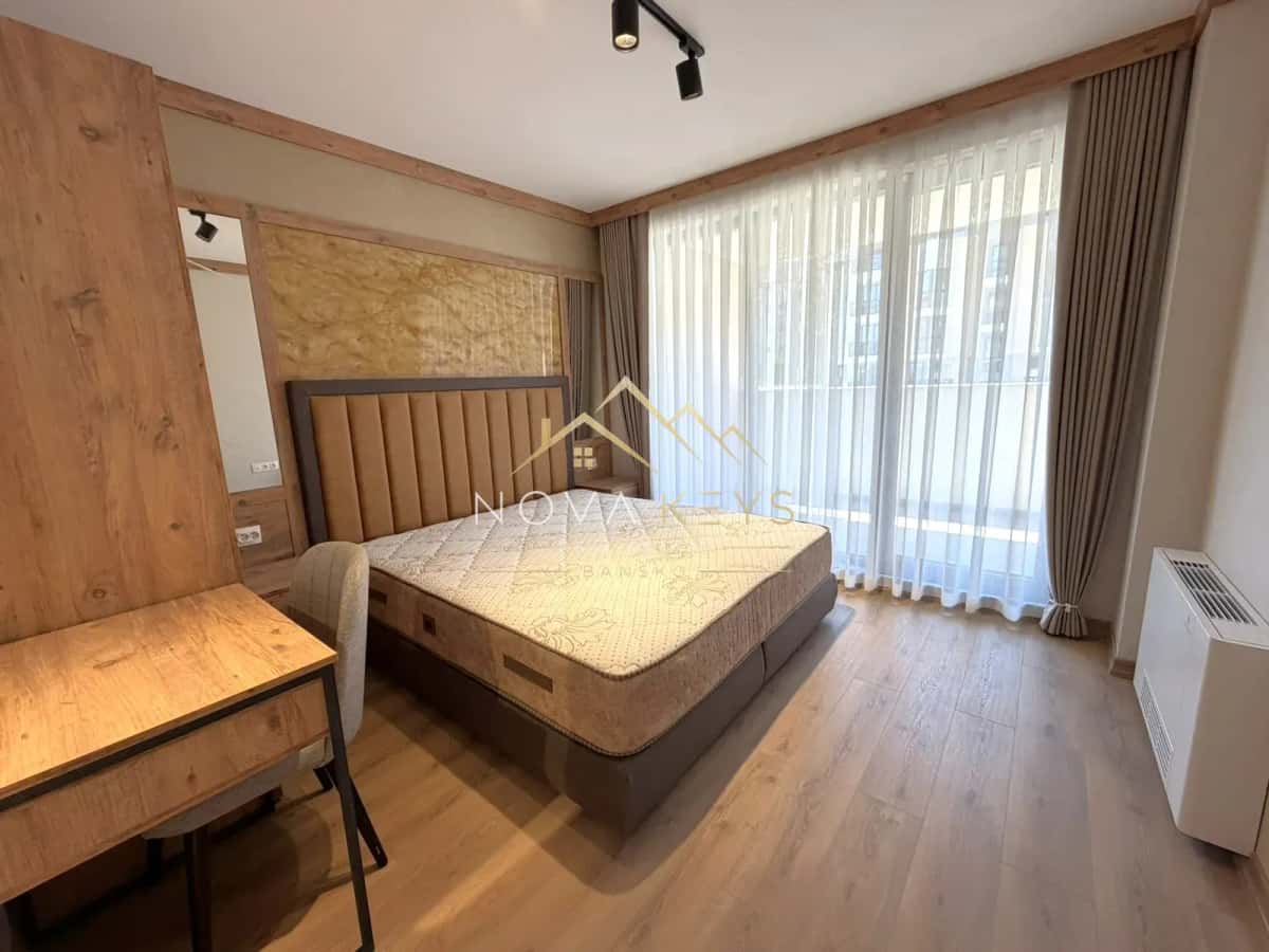 Bedroom with bed and large windows, two-bedroom apartment for sale in the Bansko ski area.
