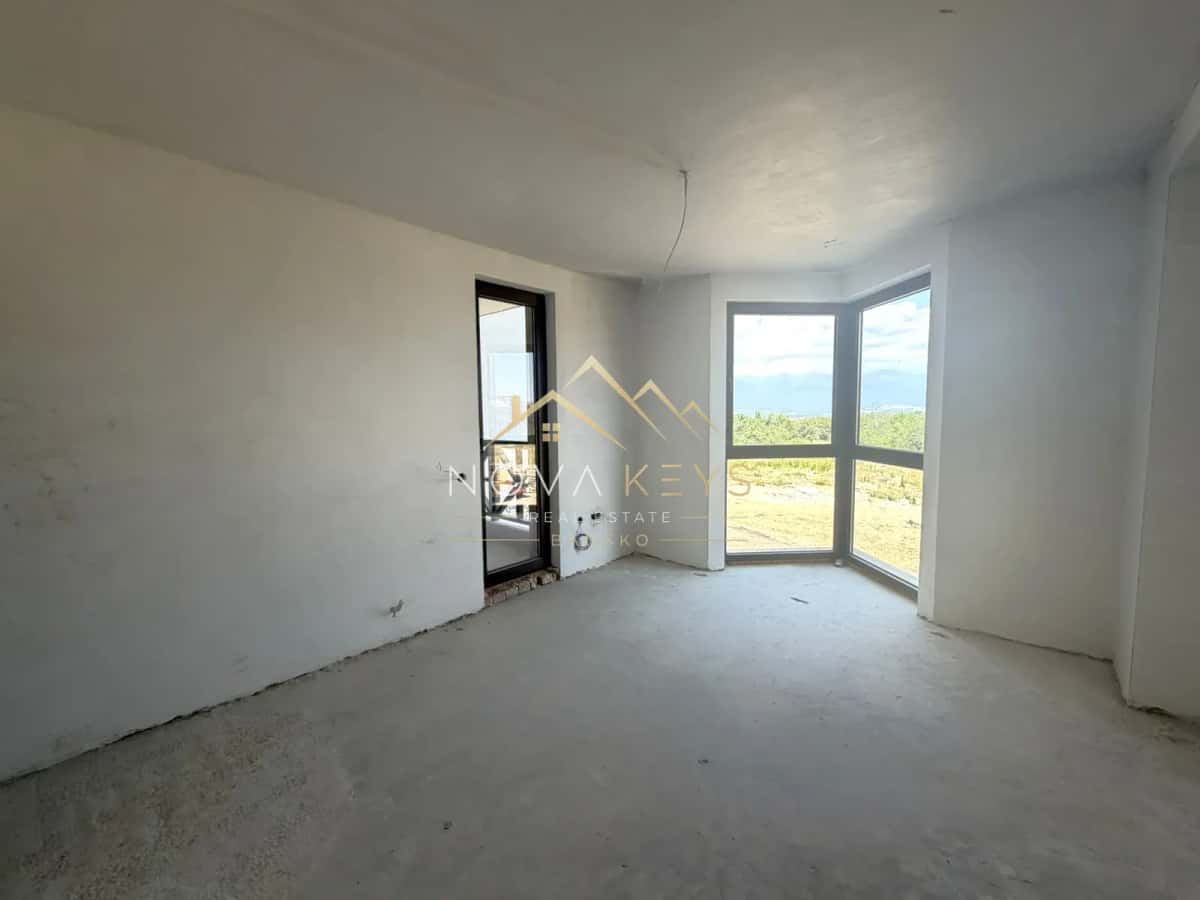 Unfinished room with corner window, three-bedroom apartment for sale in the Bansko ski area.