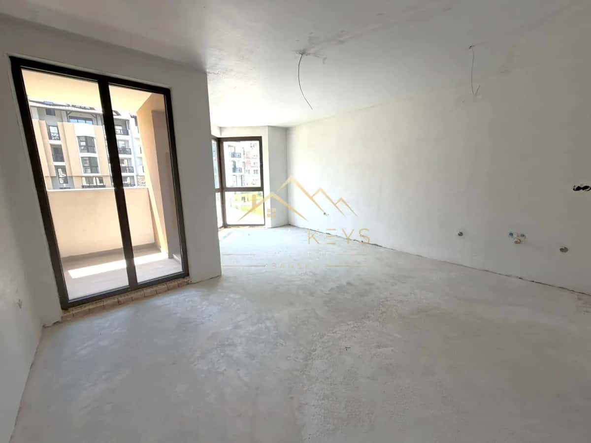 unfinished empty room with balcony doors, studio for sale in the Bansko ski area.