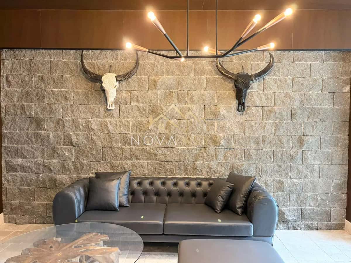 lounge with leather sofa and stone accent wall, two-bedroom apartment for sale in the Bansko ski area.