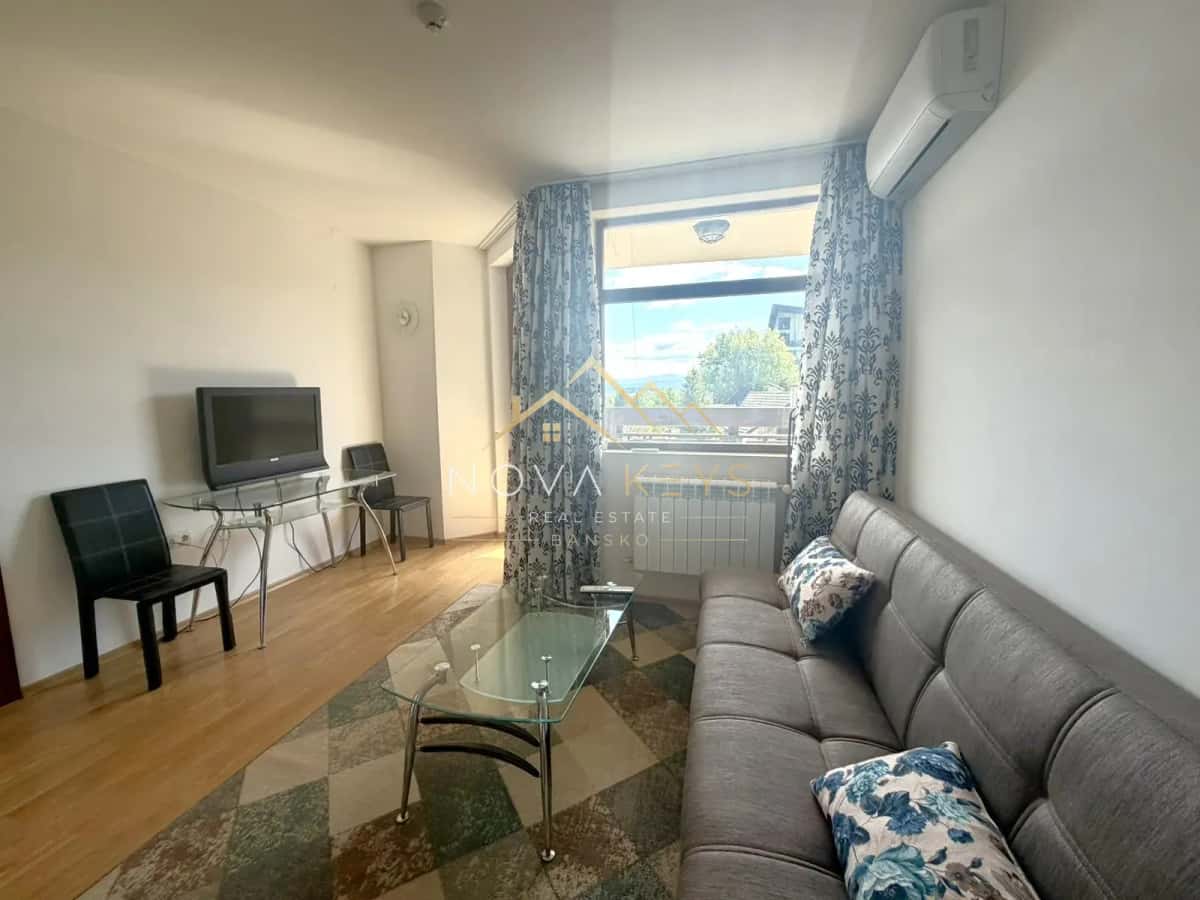 Living room with gray sofa and glass coffee table, two-bedroom apartment for sale in Razlog.