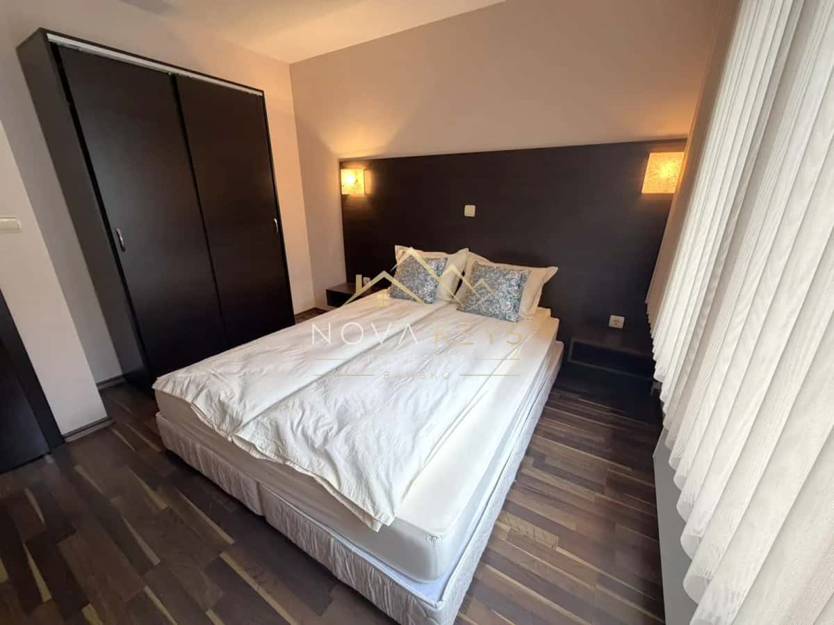 Bedroom with double bed, wardrobe, and wall lights, three-bedroom apartment for rent in the Bansko ski area.