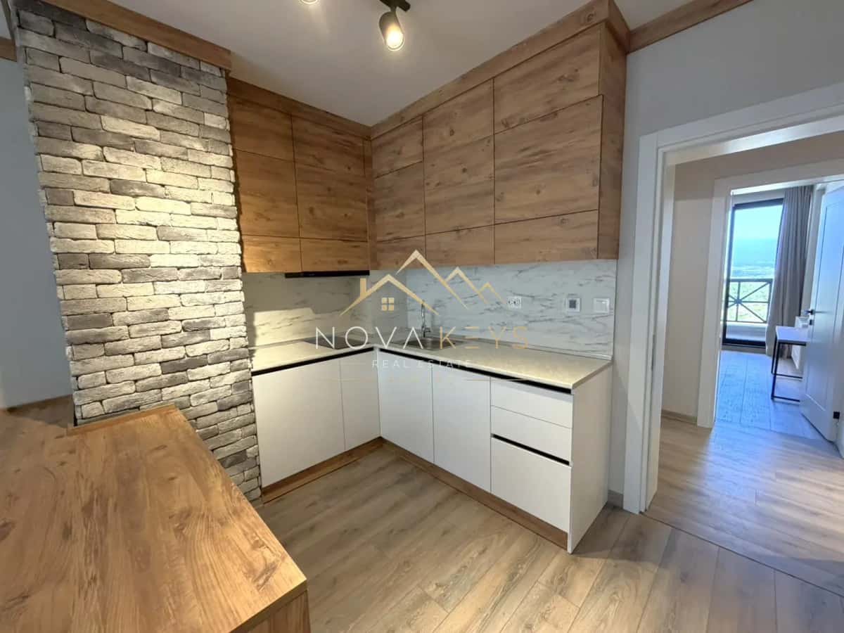 Modern kitchen corner with wood cabinets and brick accent wall, three-bedroom apartment for sale in the Bansko ski area.