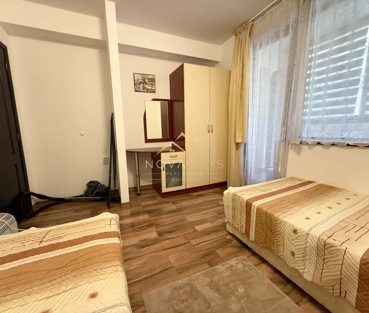 Small bedroom with two single beds and a wardrobe, three-bedroom apartment for rent in Bansko centre.