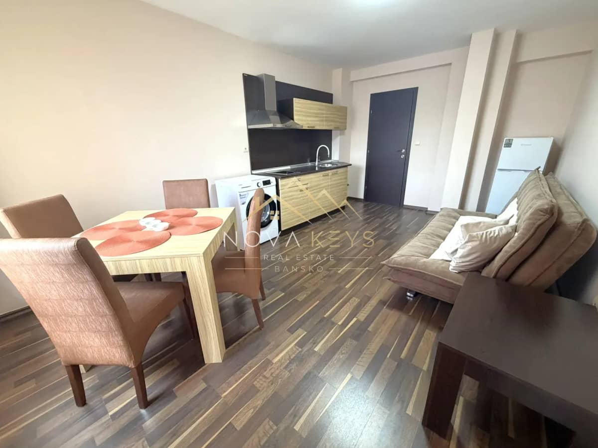 Open-plan living room with kitchenette and dining table, three-bedroom apartment for rent in the Bansko ski area.