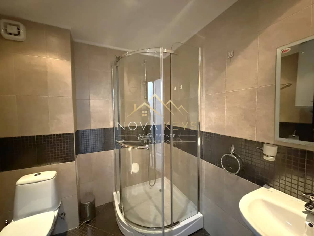 Bathroom with curved glass shower and toilet, three-bedroom apartment for rent in the Bansko ski area.