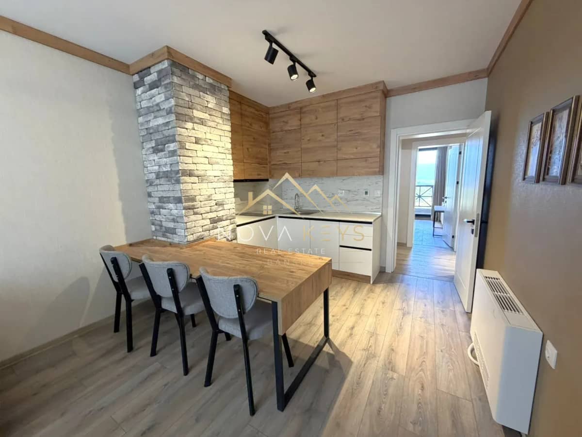 Modern kitchen dining area with wooden table and chairs, three-bedroom apartment for sale in the Bansko ski area.