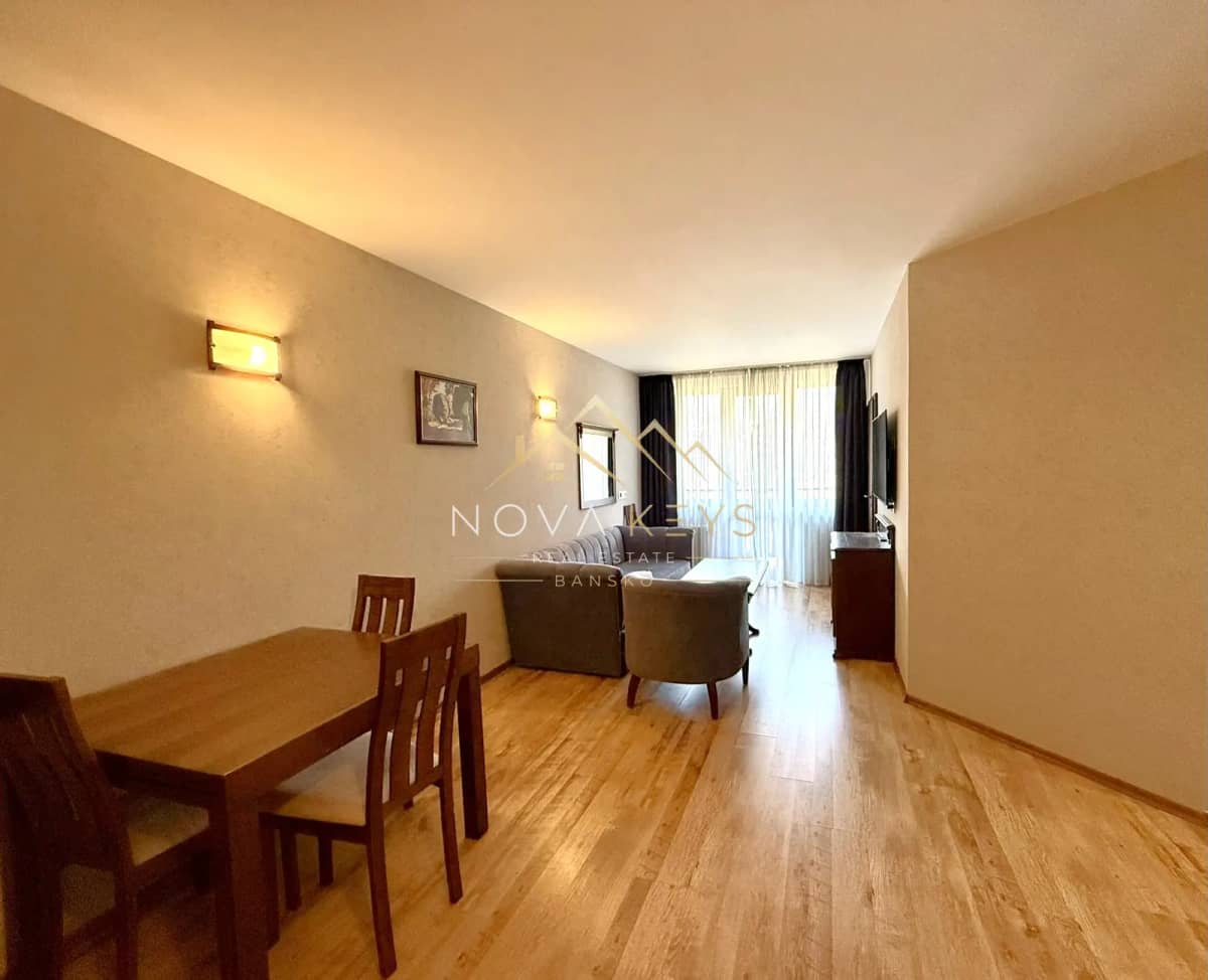 Living room with dining table and sofa, two-bedroom apartment for sale in the Bansko ski area.