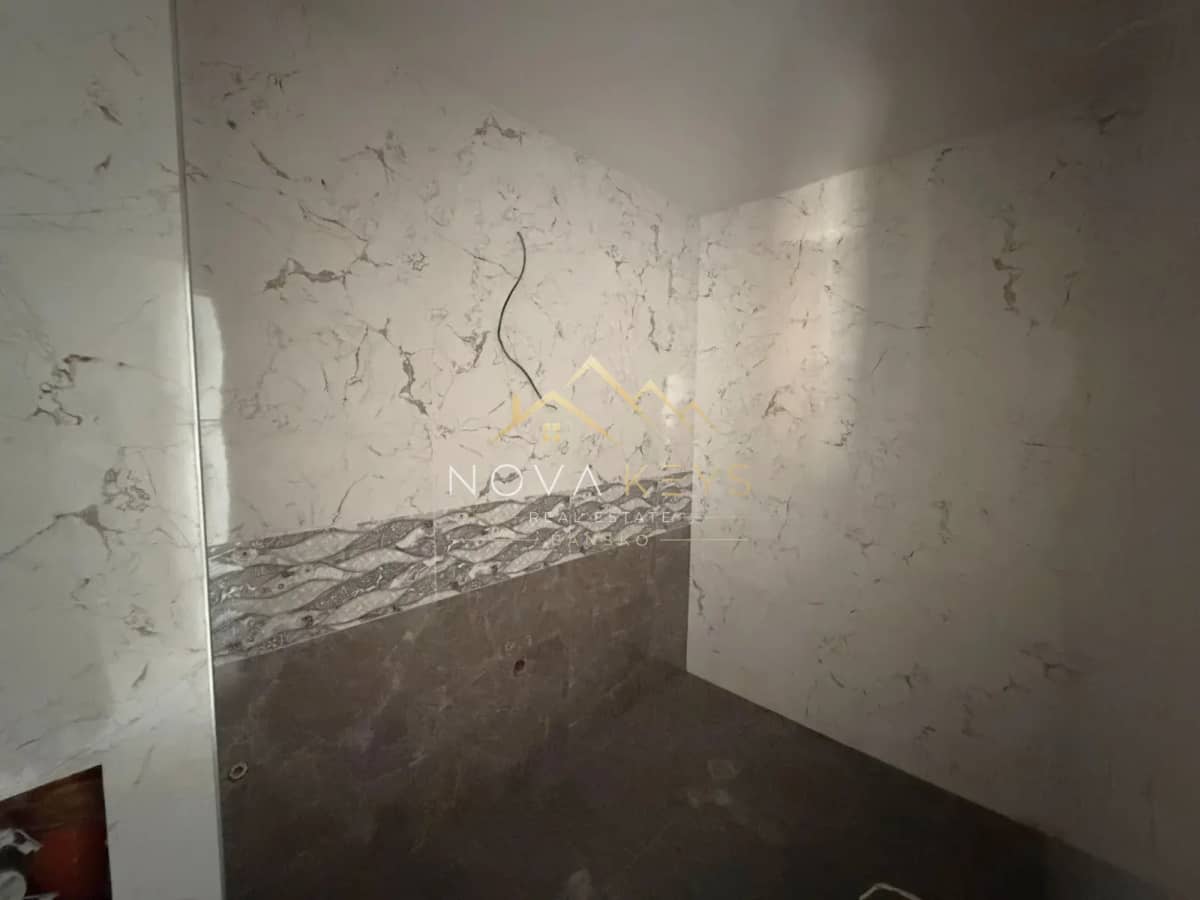 Unfinished tiled bathroom wall, studio for sale in the Bansko ski area.