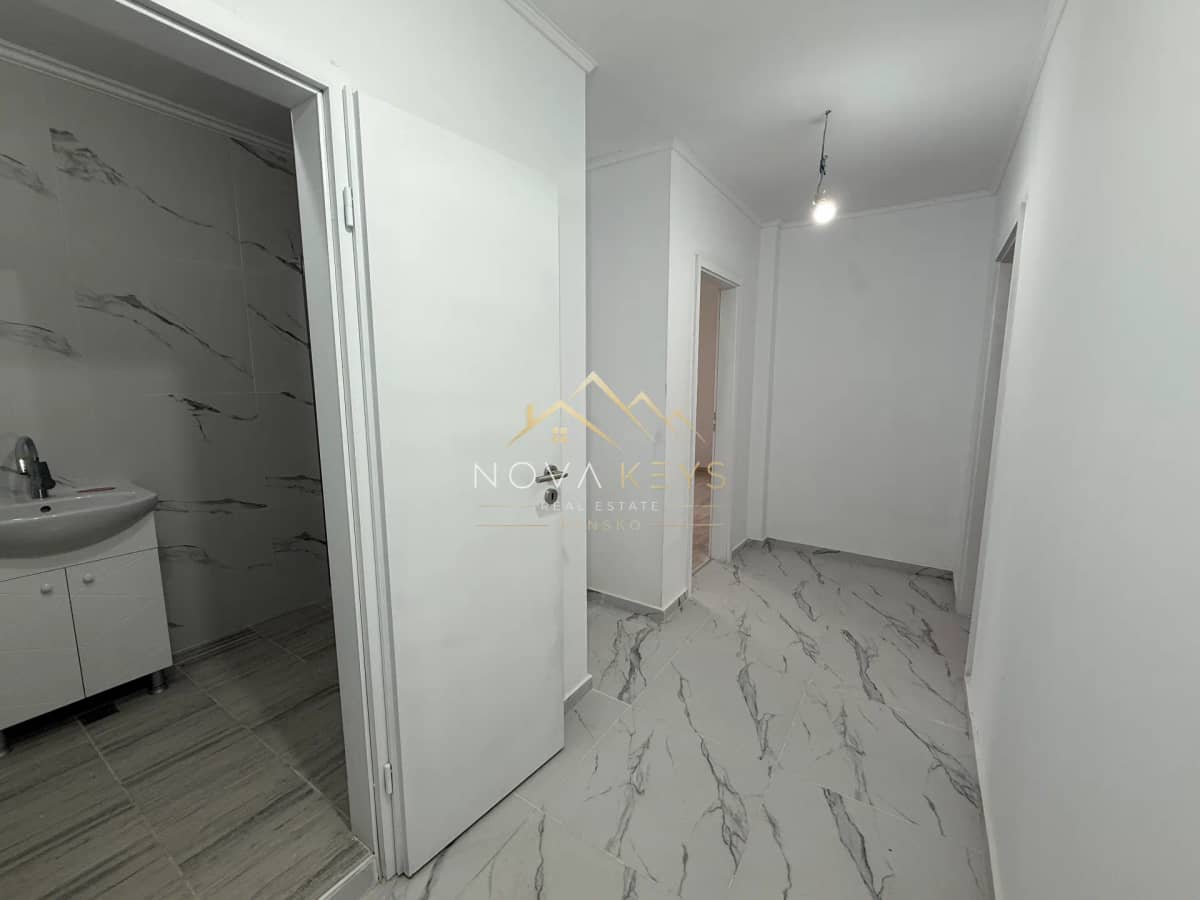 empty hallway with marble-pattern floor and open bathroom doorway, two-bedroom apartment for sale in Bansko centre.