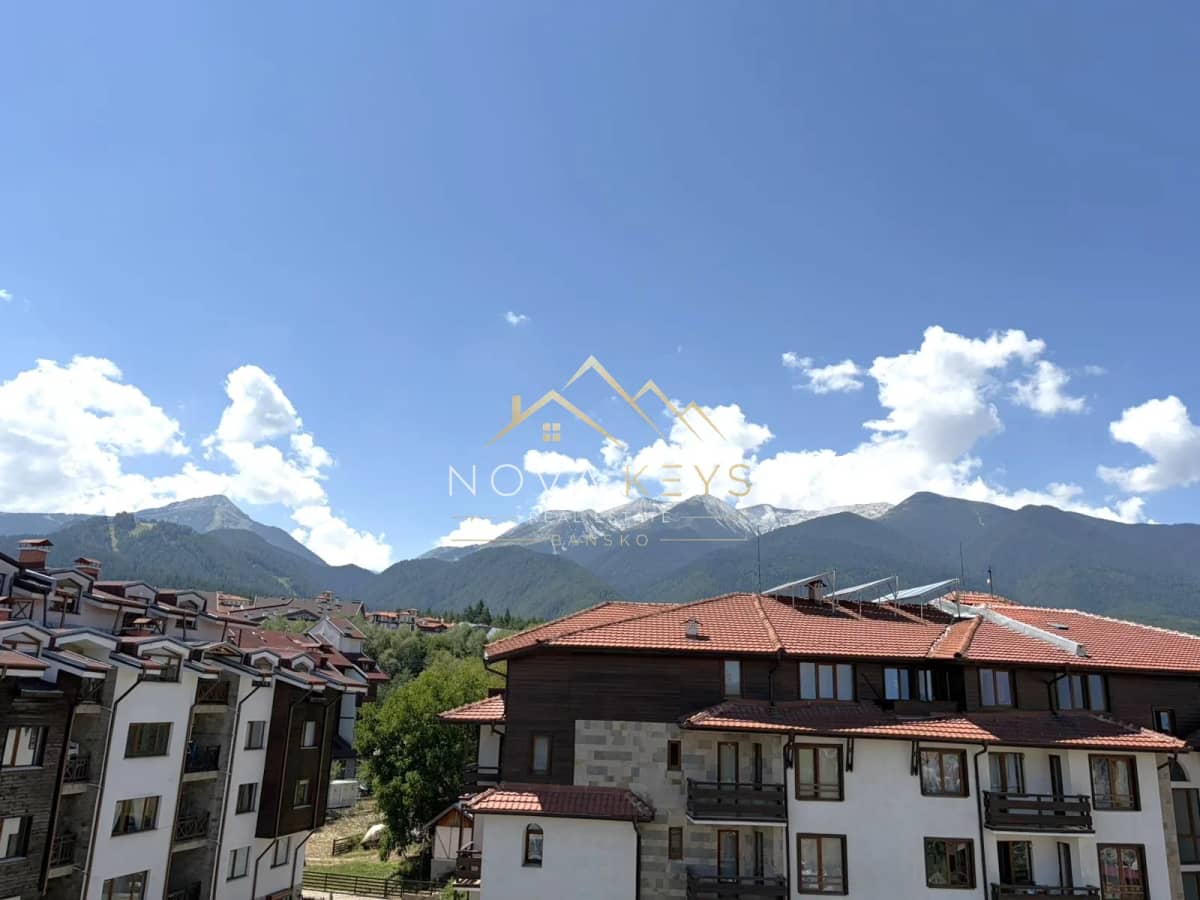 Mountain view over red-roofed buildings, two-bedroom apartment for sale in the Bansko ski area.