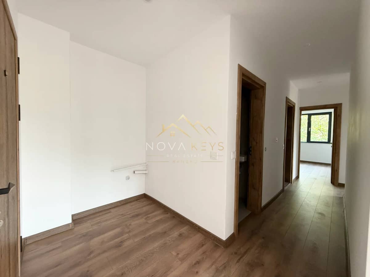 Empty hallway with wood flooring and doorways, three-bedroom apartment for sale in the Bansko ski area.