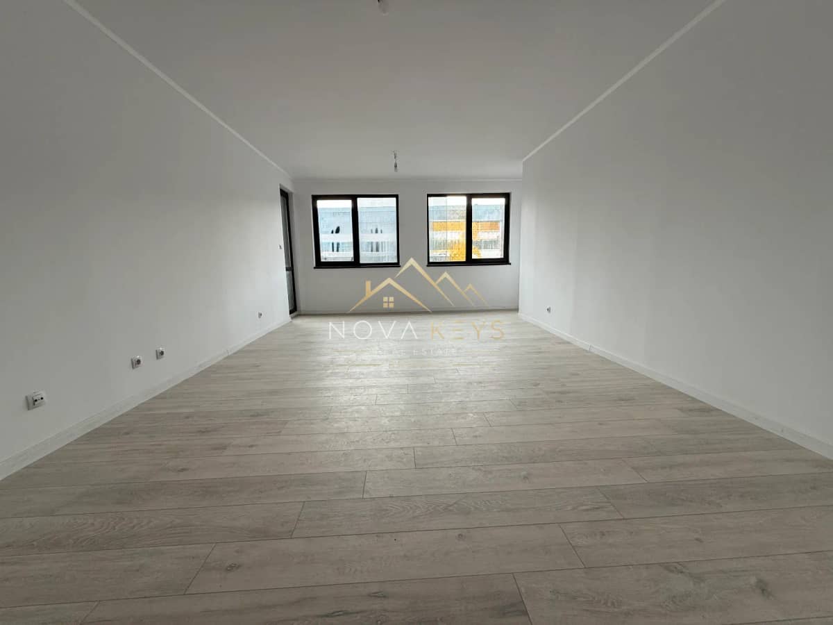 unfurnished room with wood-look flooring and two windows, two-bedroom apartment for sale in Bansko.