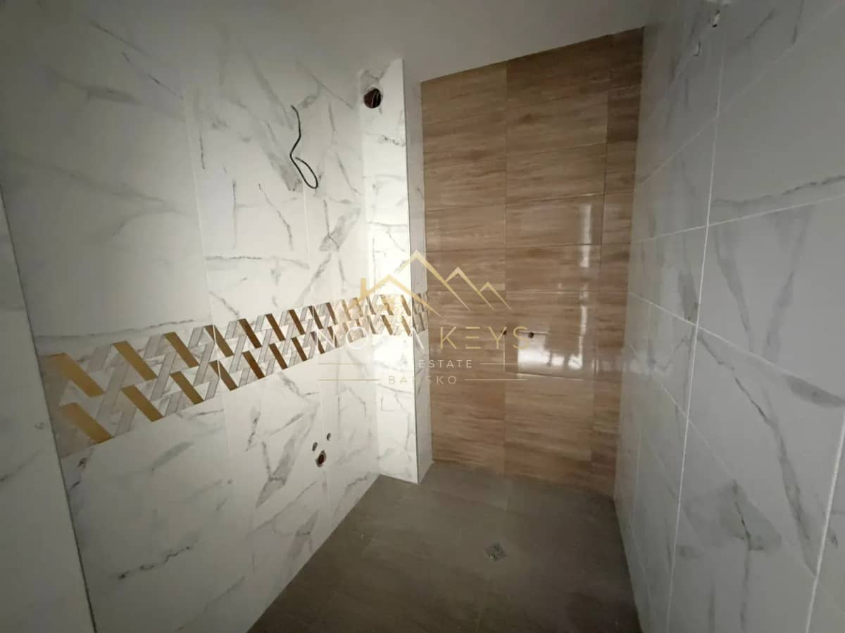 tiled shower room with wood-look wall panel, three-bedroom apartment for sale in the Bansko ski area.