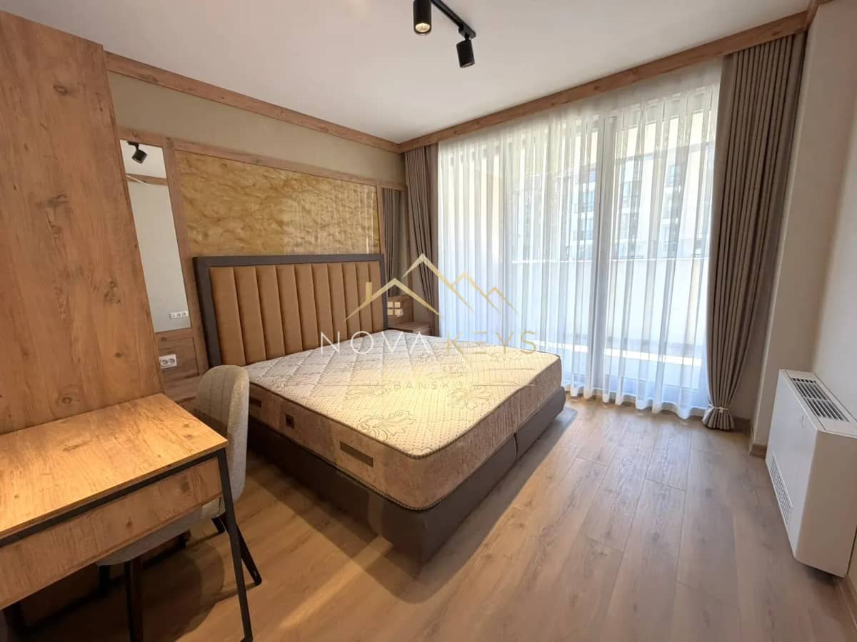 Bedroom with bed and large windows, two-bedroom apartment for sale in the Bansko ski area.
