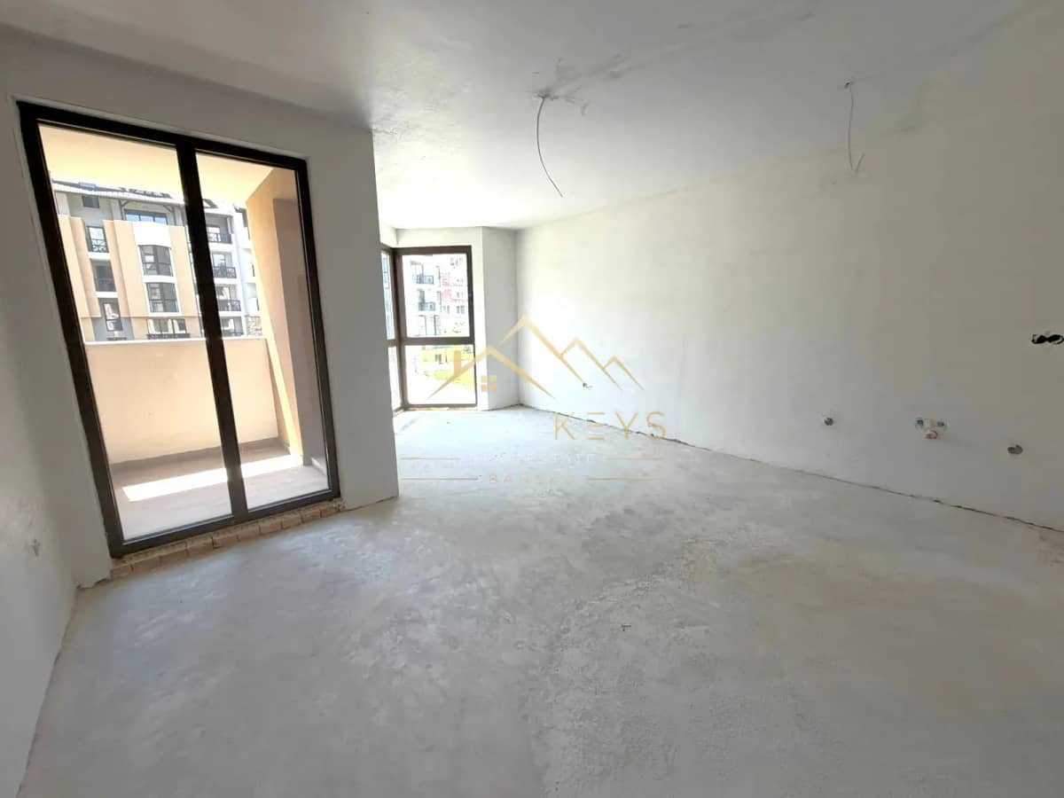 unfinished empty room with balcony doors, studio for sale in the Bansko ski area.