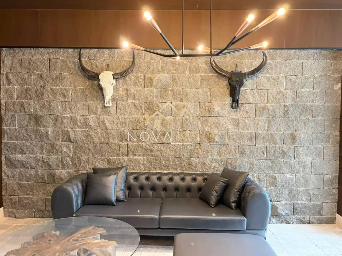 lounge with leather sofa and stone accent wall, two-bedroom apartment for sale in the Bansko ski area.