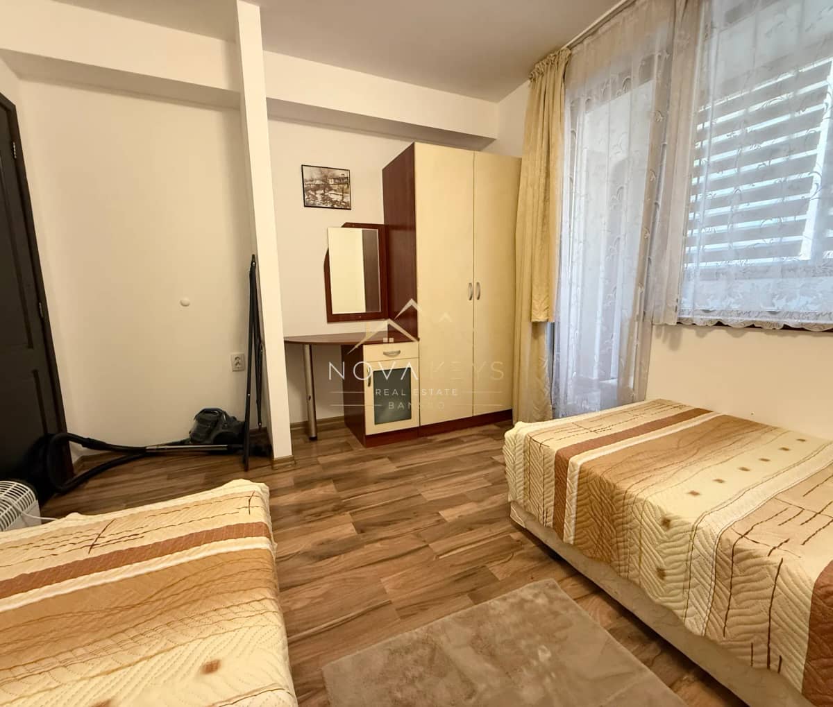 Small bedroom with two single beds and a wardrobe, three-bedroom apartment for rent in Bansko centre.