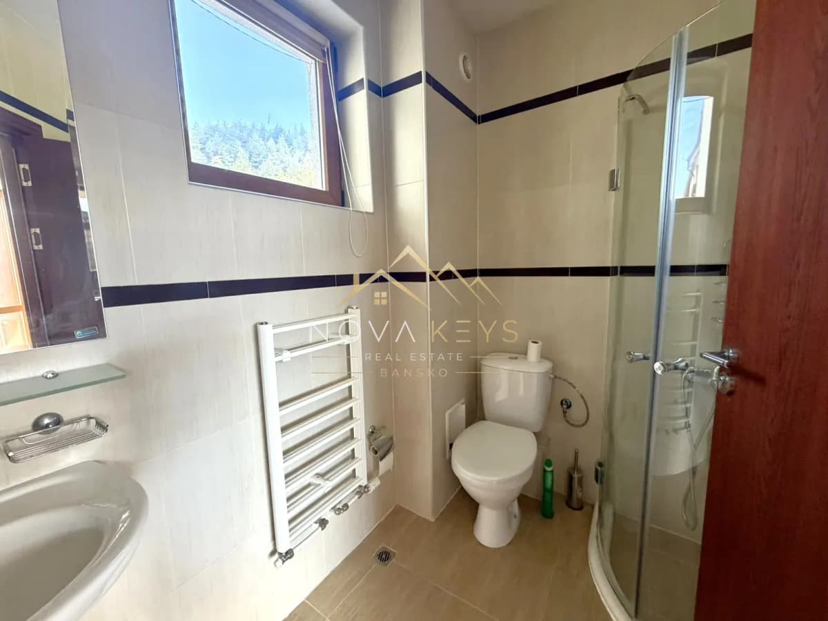 Bathroom with shower enclosure, toilet, and window, two-bedroom apartment for sale in Razlog.