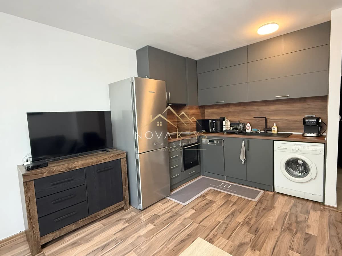 Modern kitchen with grey cabinets and TV, three-bedroom apartment for rent in Bansko centre.