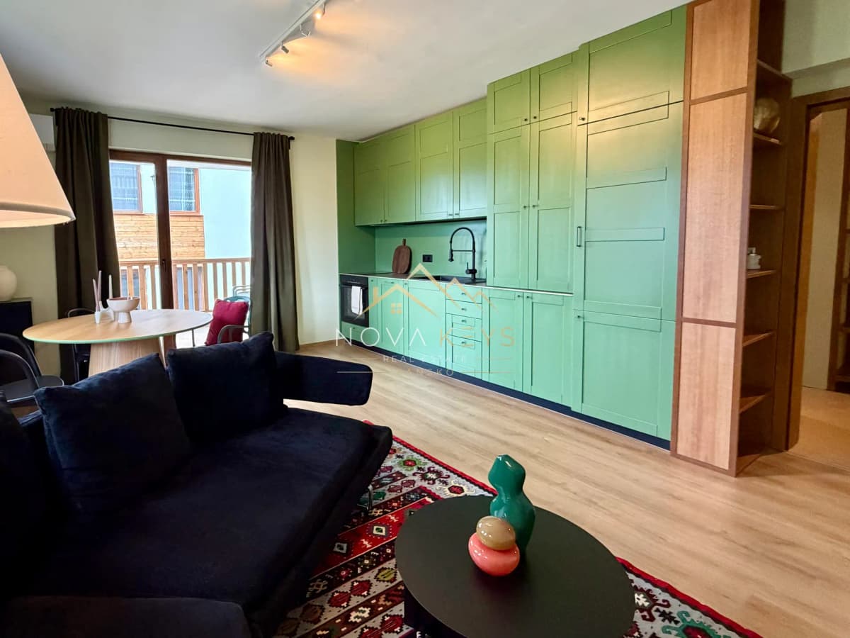 Open-plan living room with green kitchen cabinets, two-bedroom apartment for sale in Pirin Golf.