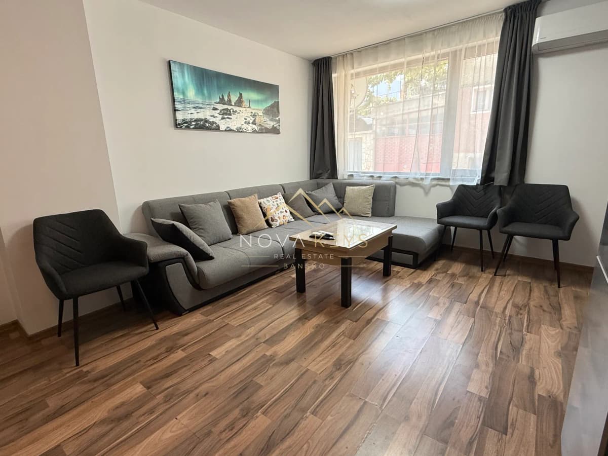 Living room with sectional sofa and coffee table, three-bedroom apartment for rent in Bansko centre.