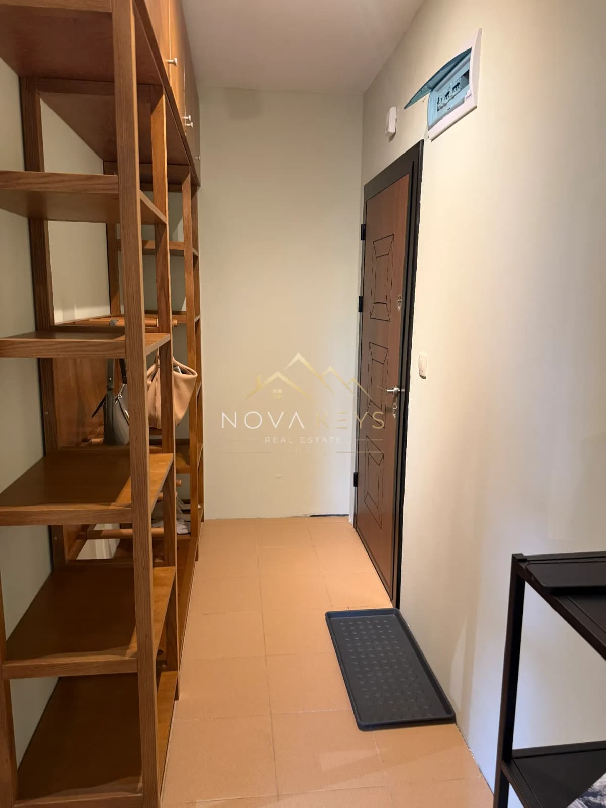 Narrow hallway with wooden shelving and a brown door, two-bedroom apartment for sale in Pirin Golf.
