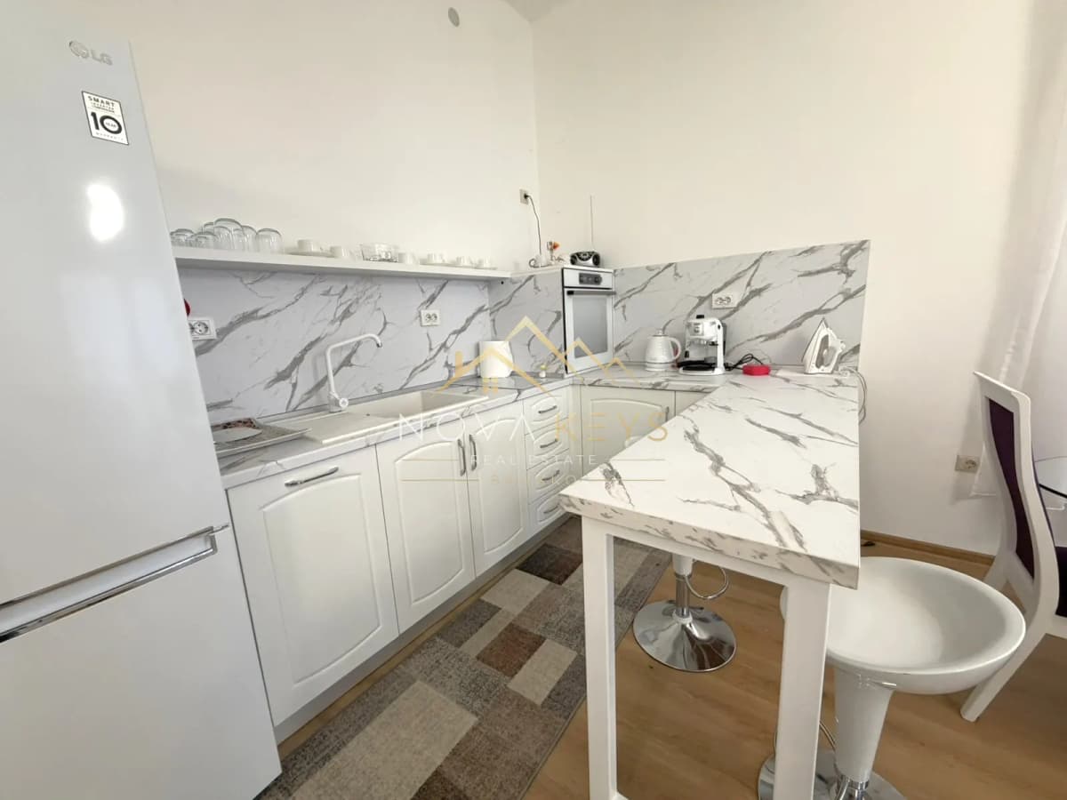 Modern white kitchen with marble breakfast bar, two-bedroom apartment for sale in Pirin Golf.