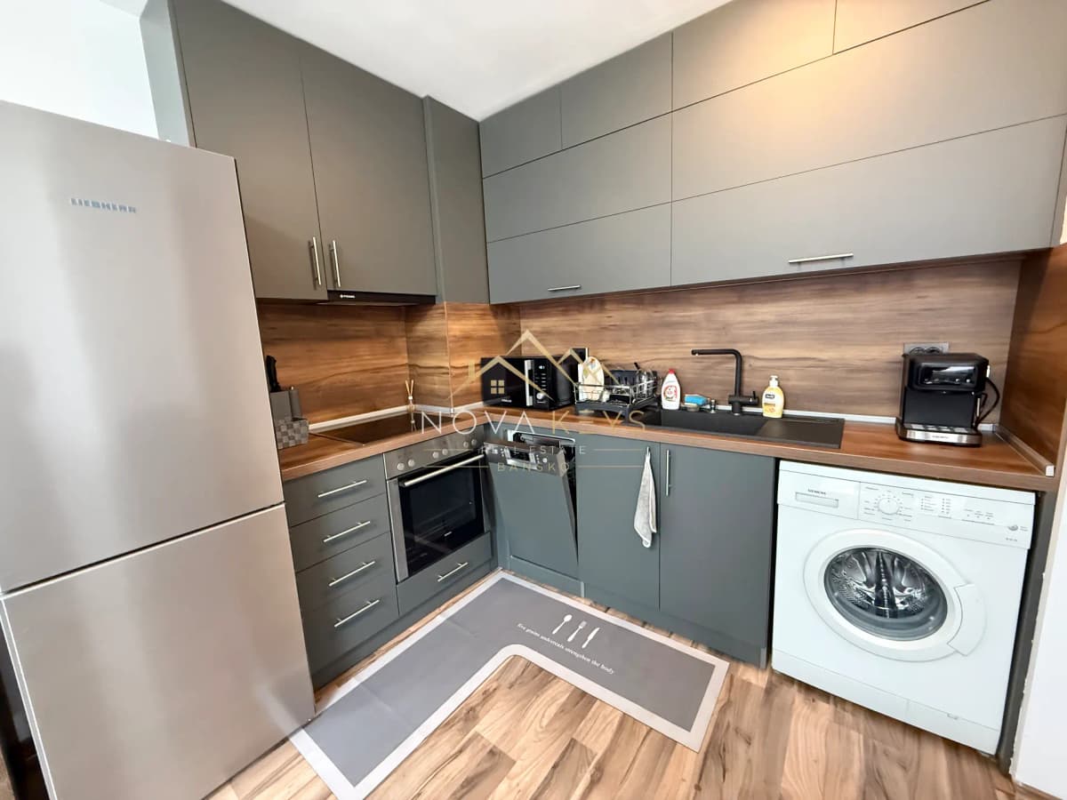 Modern kitchen with gray cabinets and appliances, three-bedroom apartment for rent in Bansko centre.