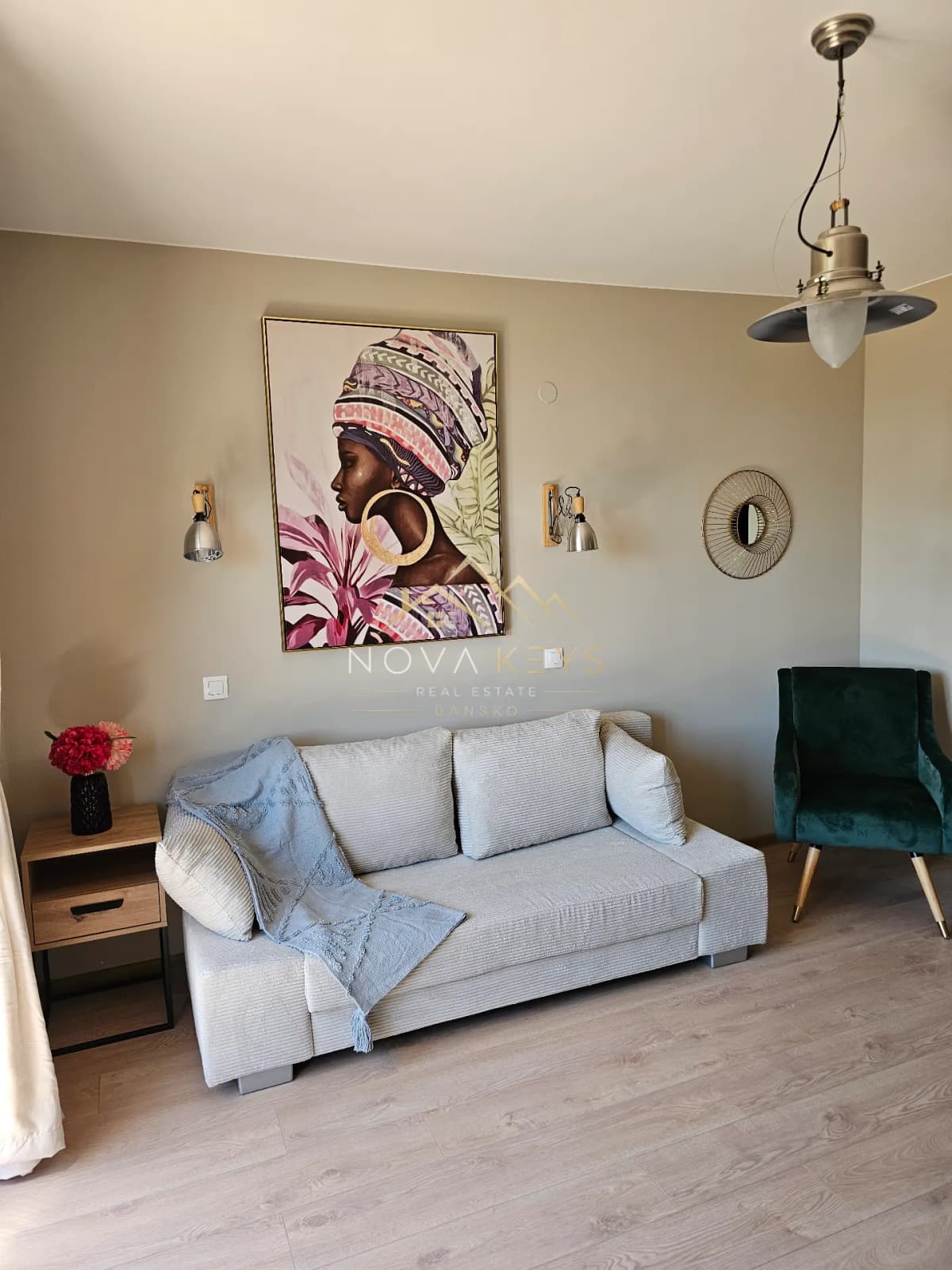 living room with sofa, armchair, and wall art, studio for sale in the Bansko ski area.