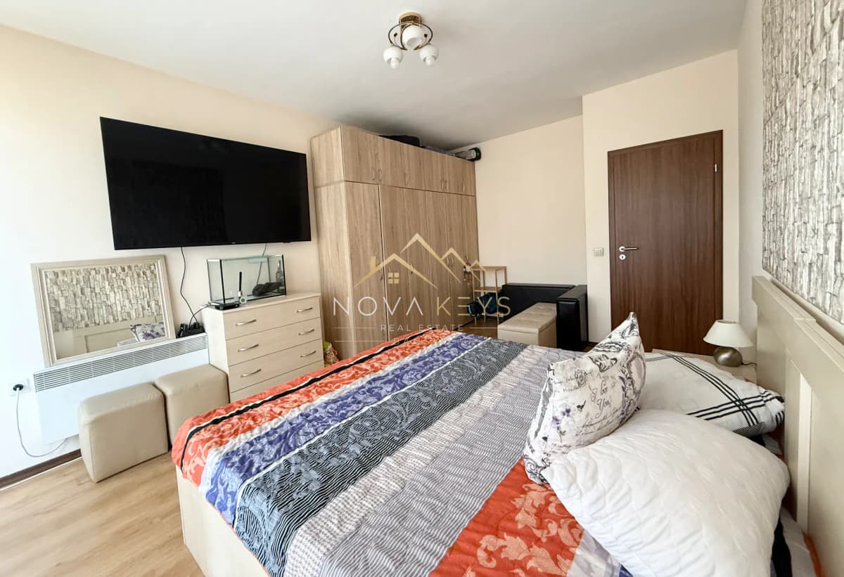 bedroom with double bed, wall-mounted TV, and wardrobe, three-bedroom apartment for sale in Bansko.