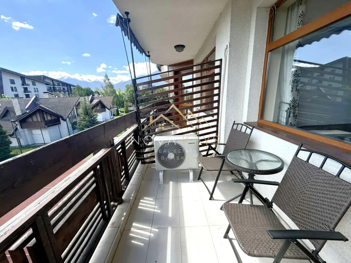 Covered balcony with chairs and glass table, two-bedroom apartment for sale in Razlog.