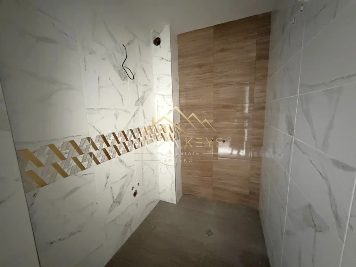 tiled shower room with wood-look wall panel, three-bedroom apartment for sale in the Bansko ski area.