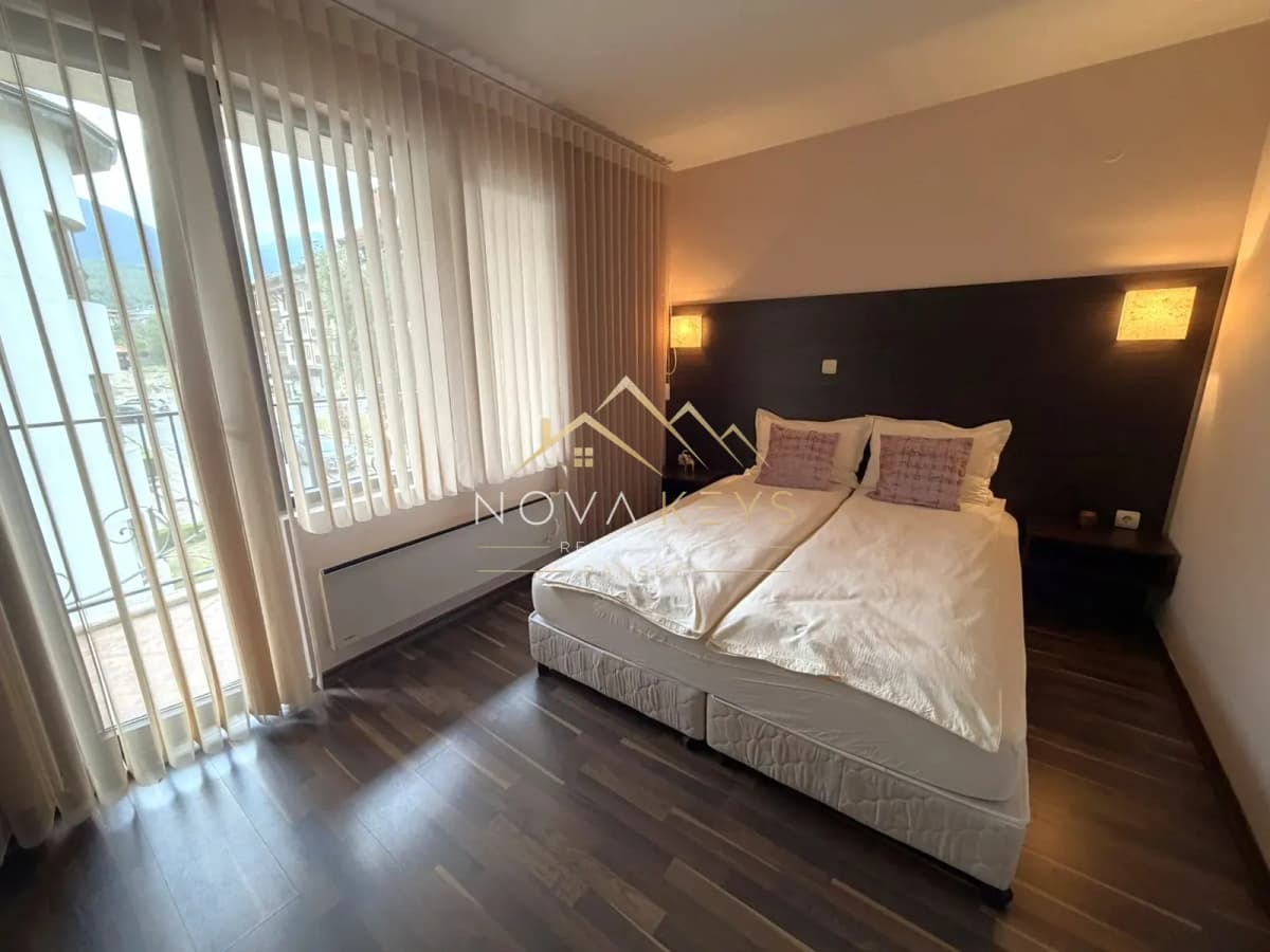 Bedroom with double bed and vertical blinds, three-bedroom apartment for rent in the Bansko ski area.